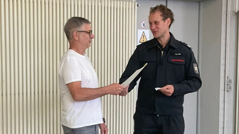 Feuerwehrmann hängt den Helm an den Nagel